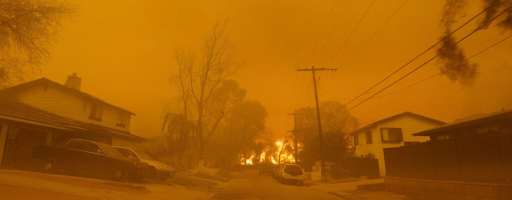 Homes in a wildfire zone blanketed by smoke—damage like this may qualify for insurance coverage under California law, even if it isn’t visible.